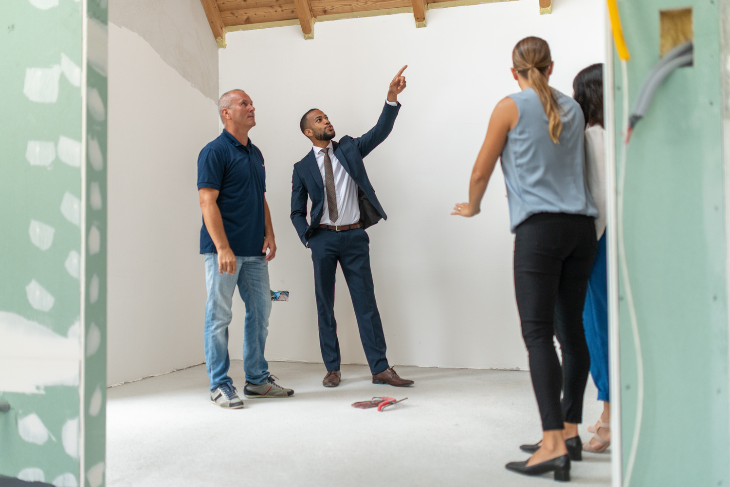 Real-estate investor talking with experts in house under construction